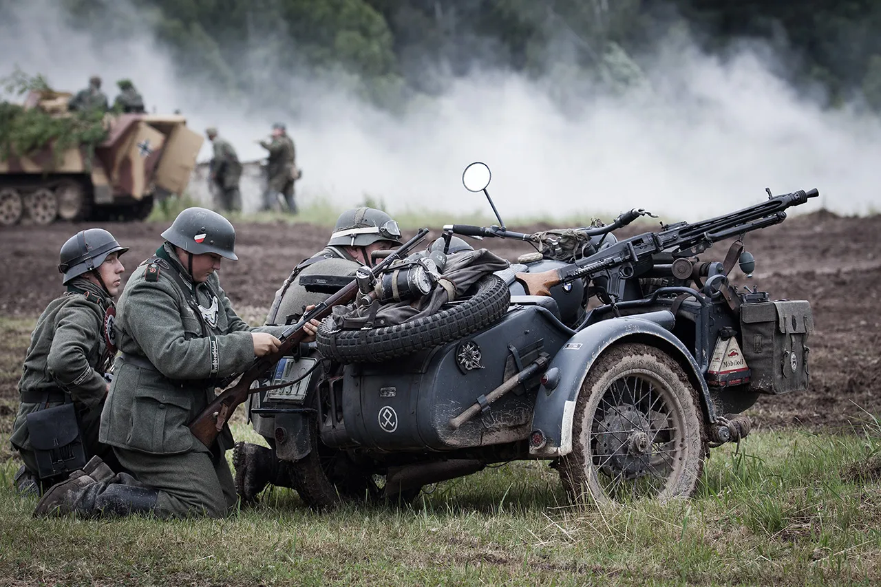 Vojáci kryjící se za motocyklem BMW R75 se sajdkárou a kulometem MG 34 během dynamické ukázky na akci Bahna. V pozadí polopásový transportér.